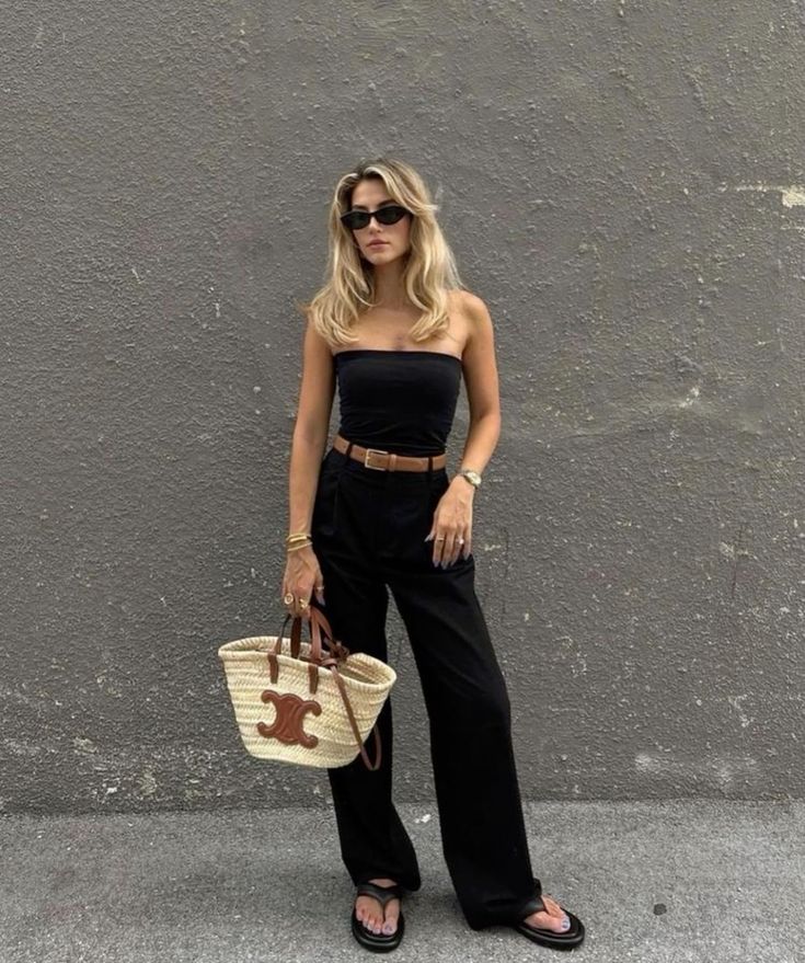 Black tube top and wide-leg trousers paired with a LOEWE straw bag